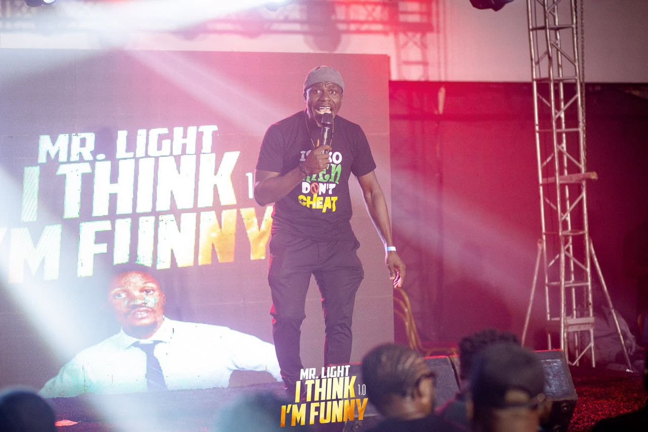 Edafe Dmouthpiece performing stand-up comedy on stage at Mr. Light I Think I'm Funny show